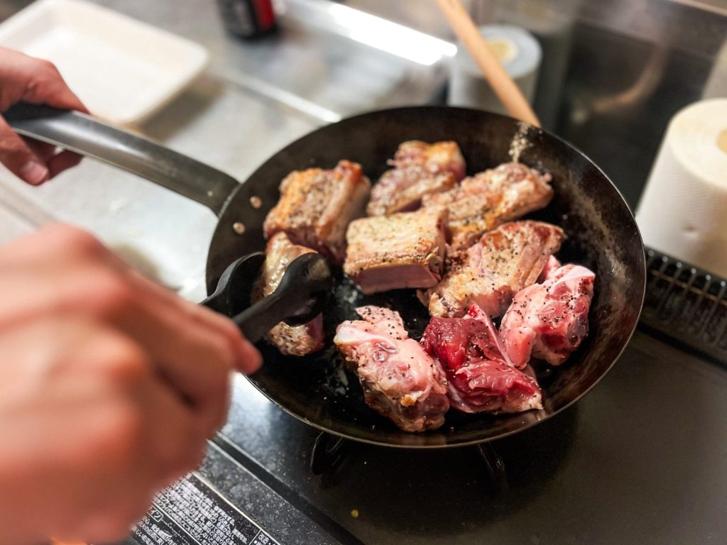 スペアリブをフライパンでこんがり焼いている。