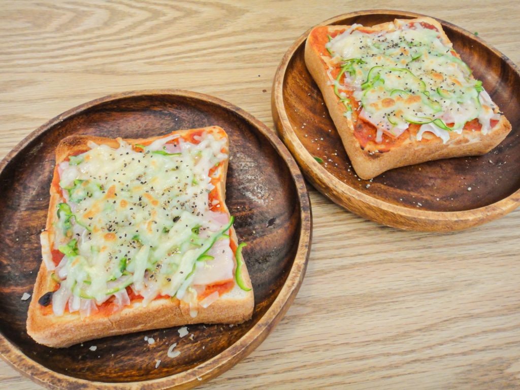 木の皿に載った焼きたてのピザトーストが2つ並んでいる。